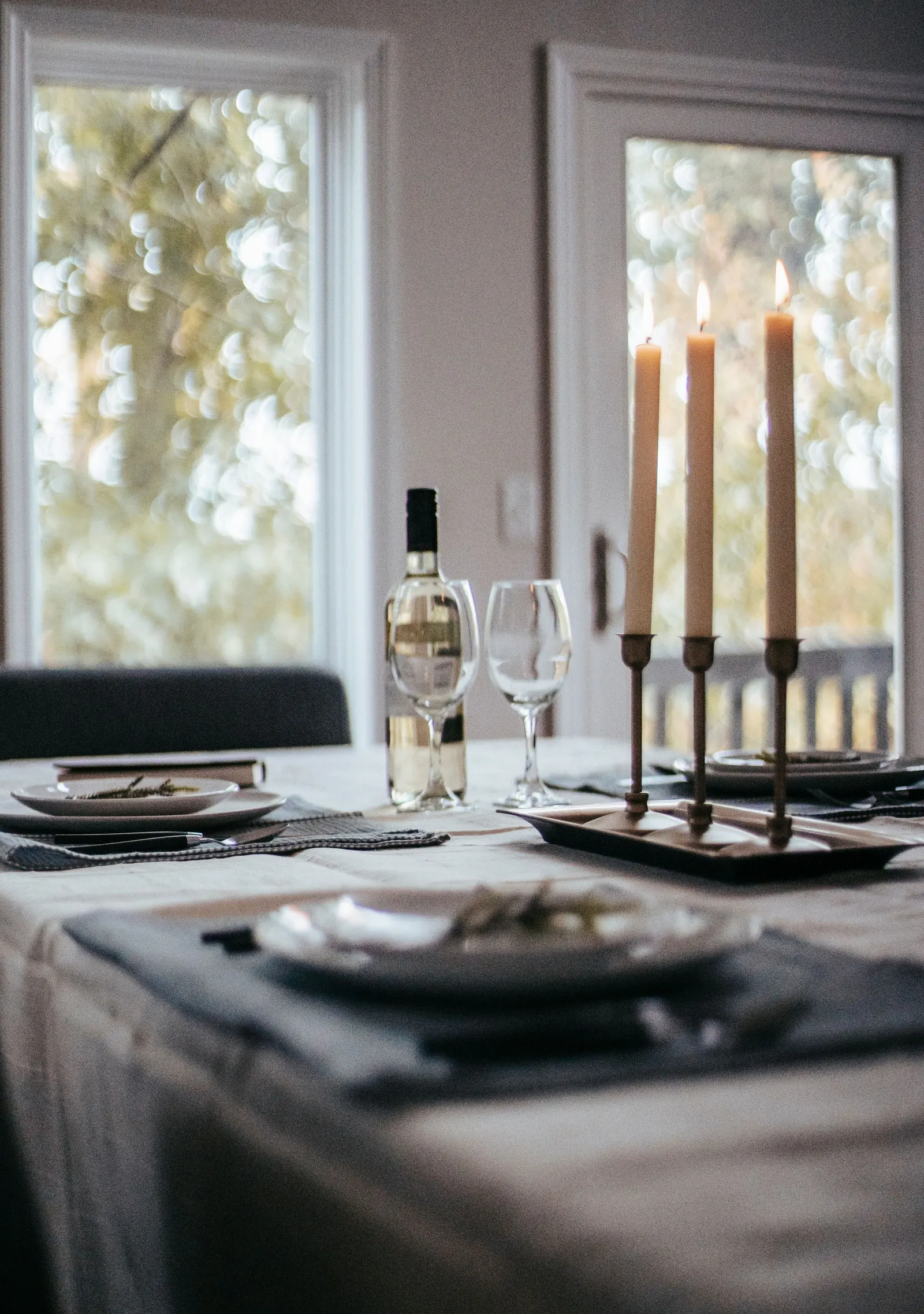 A table set with plates, wine and candles